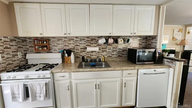 a kitchen with white cabinets and white appliances