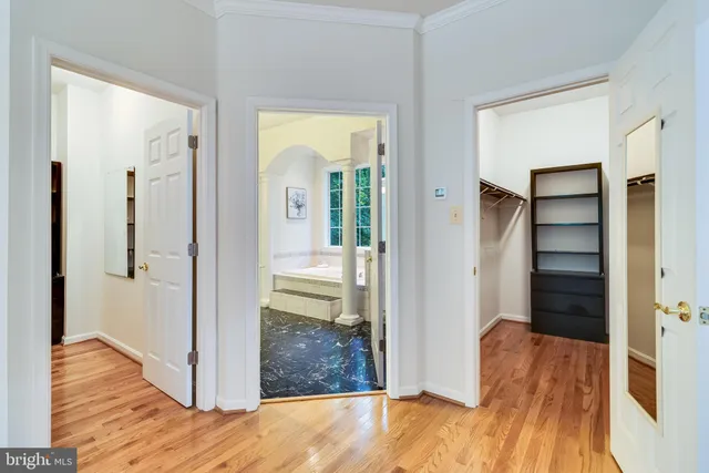 an empty room with chandelier fan and windows