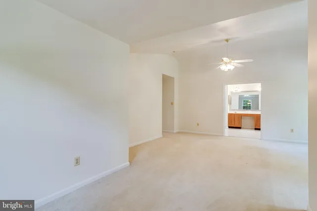a view of an empty room with wooden floor and windows