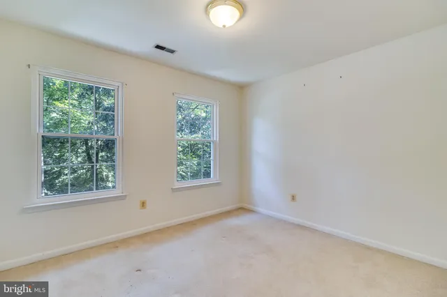 a front view of a house with a garden and trees