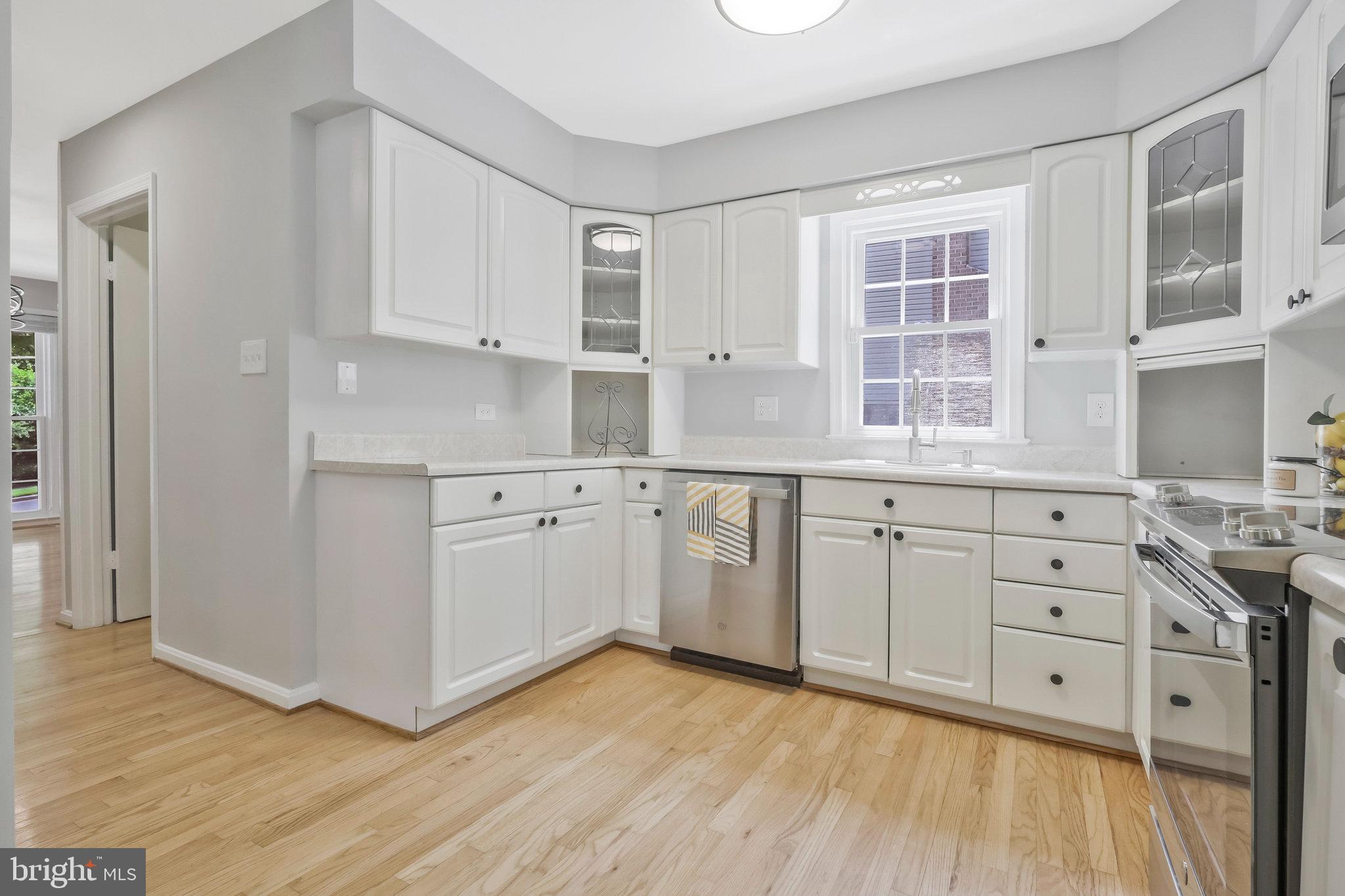 8606 Nanlee Drive Springfield, VA 22152 - Photo 16 of 70 a kitchen with granite countertop white cabinets and white appliances