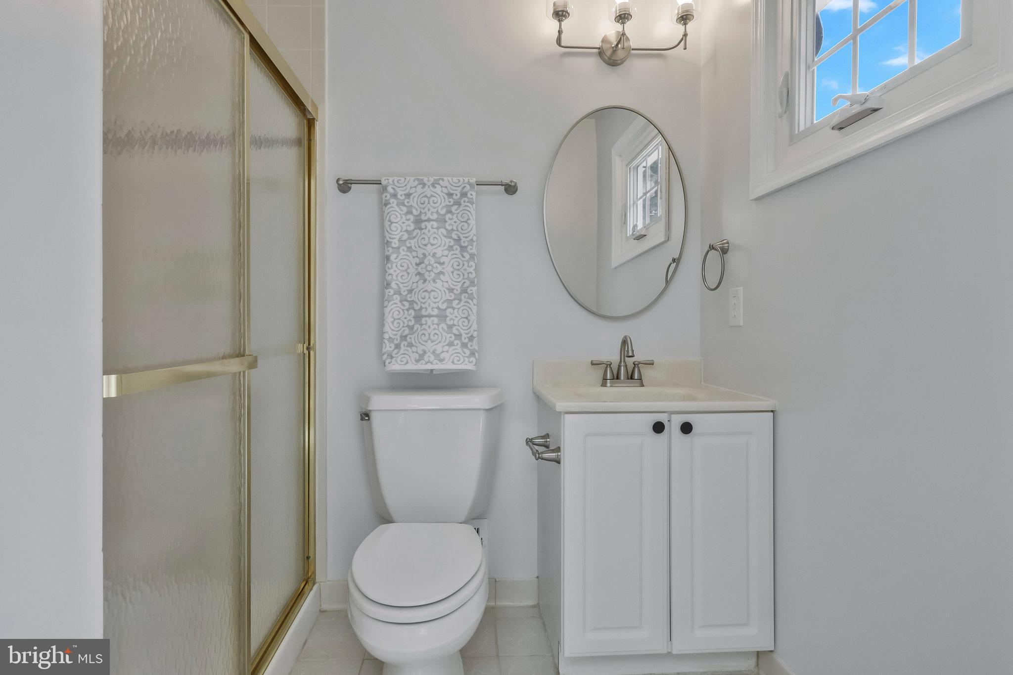 8606 Nanlee Drive Springfield, VA 22152 - Photo 34 of 70 a bathroom with a toilet a sink and mirror