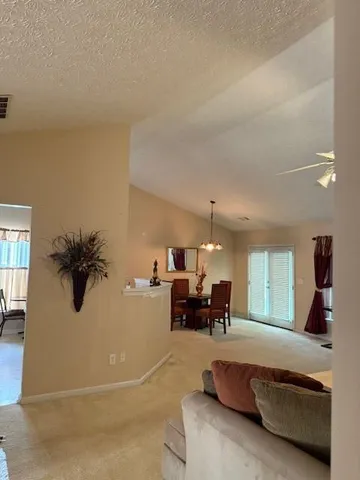 a living room with furniture and a chandelier