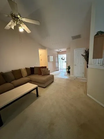 a living room with furniture and a chandelier