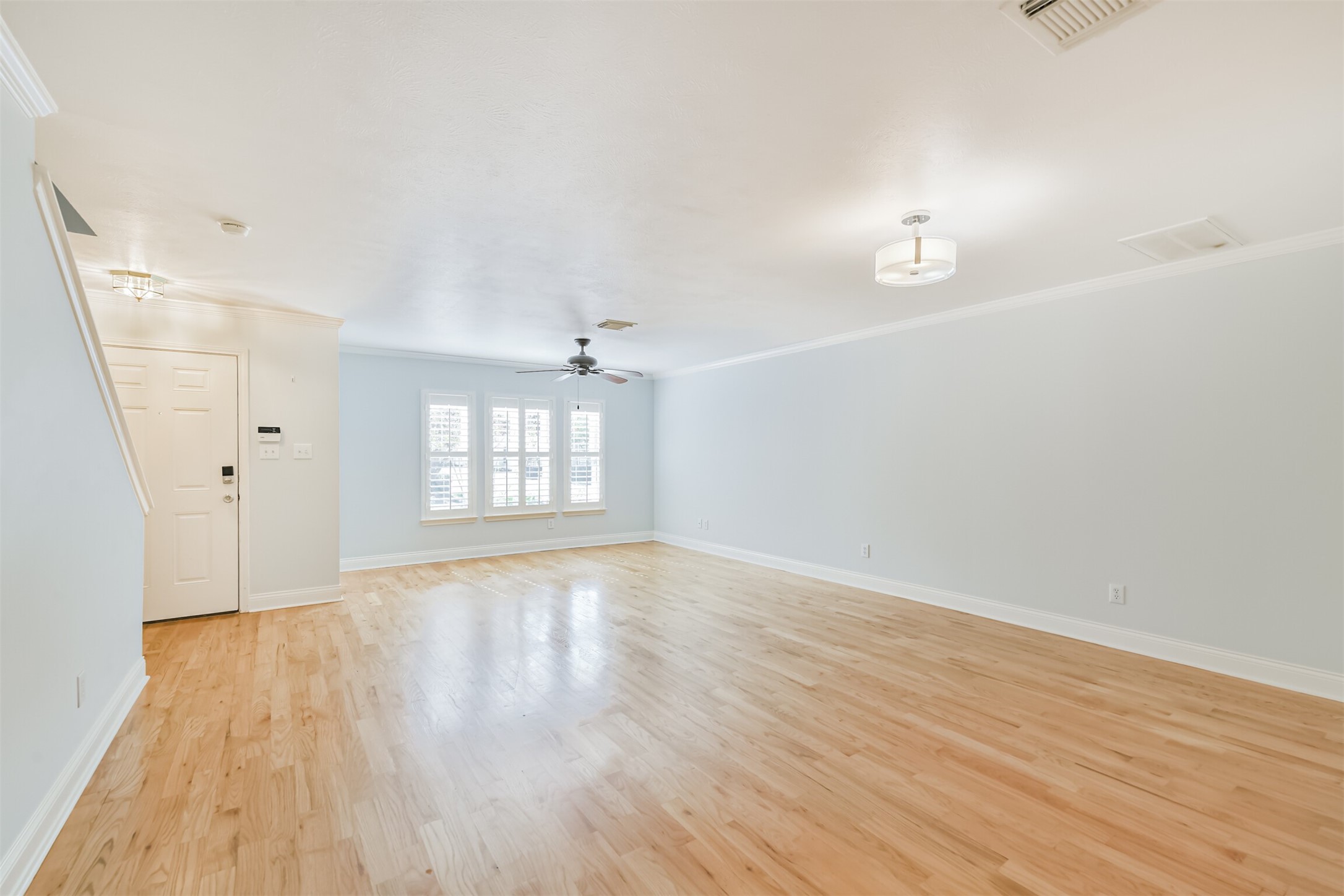 738 Redwing Pl Drive Houston, TX 77009 - Photo 3 of 23 A bright and inviting living room featuring an open-concept layout, rich hardwood floors, and seamless flow into the kitchen—perfect for modern living and entertaining.
