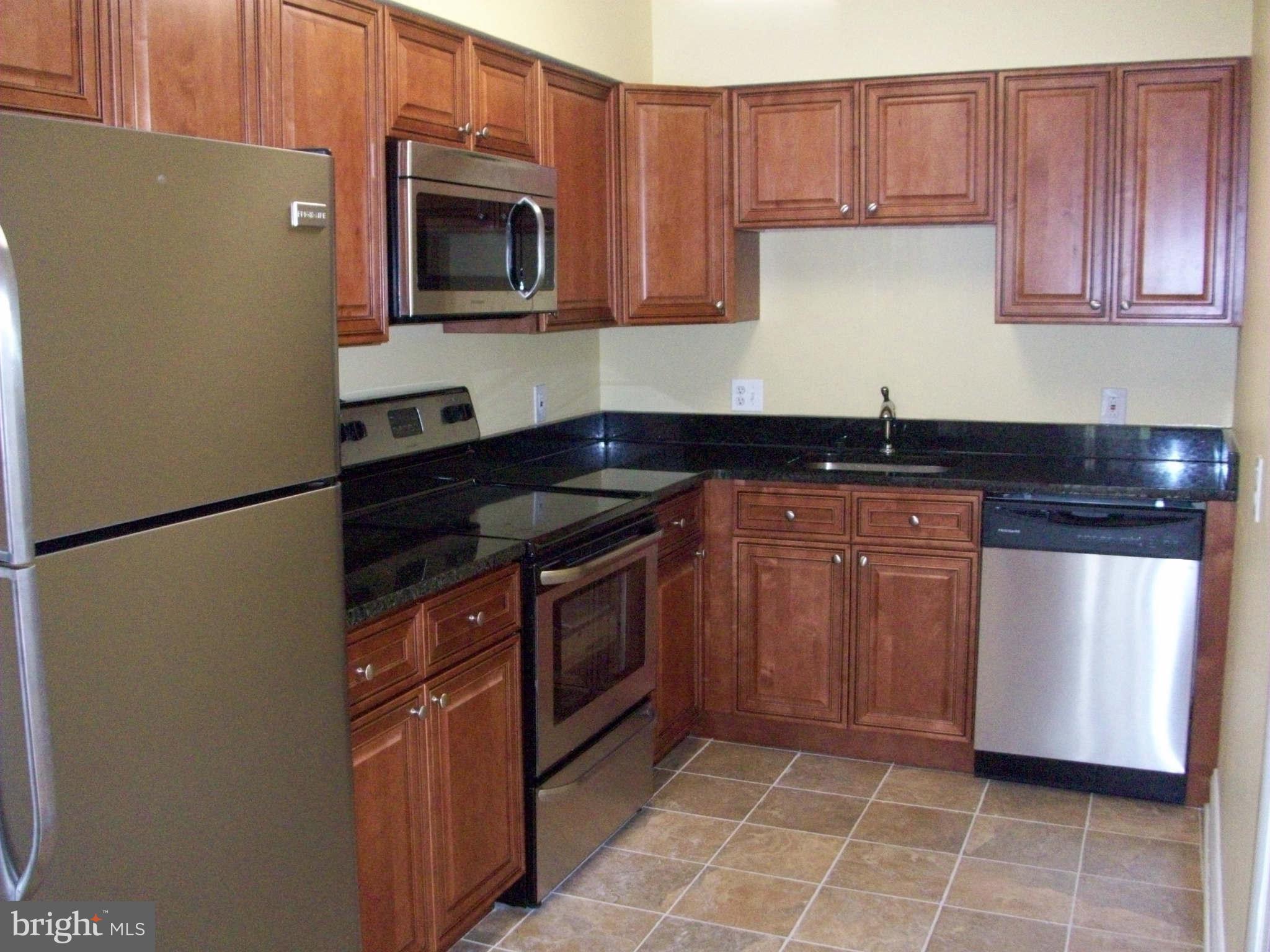 3105 Berry Road Northeast, Unit 11 Washington, DC 20018 - Photo 3 of 8 a kitchen with granite countertop a sink stove and microwave