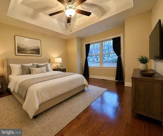 a bedroom with a large bed and a flat tv screen on dresser