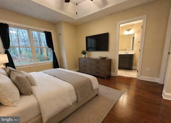 a bedroom with a bed and a flat tv screen on wall