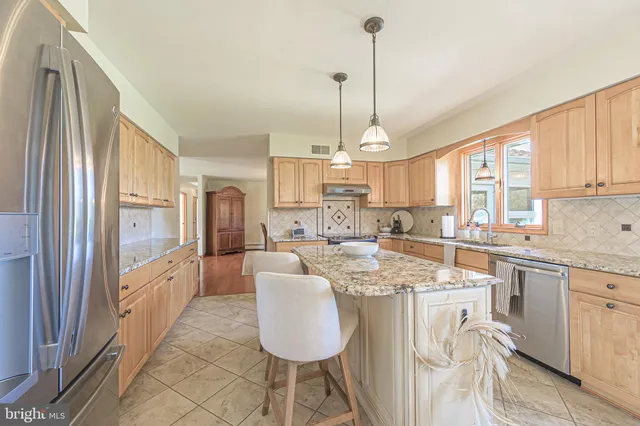 a kitchen with a dining table chairs cabinets and stainless steel appliances