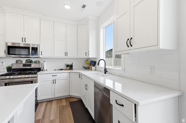 347 Ropelato Drive Logan, UT 84321 - Photo 15 of 46 White shaker cabinetry paired with light-toned countertops and a matching subway tile backsplash