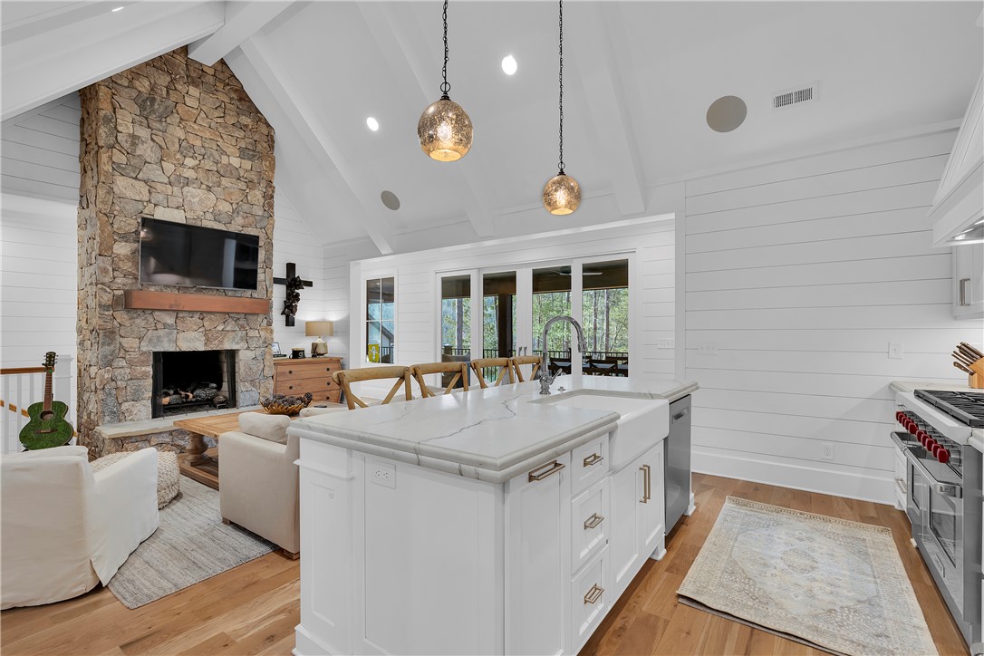 243 Quay Court Sunset, SC 29685 - Photo 11 of 46 This open concept living area features high ceilings, a kitchen island, and hardwood flooring.