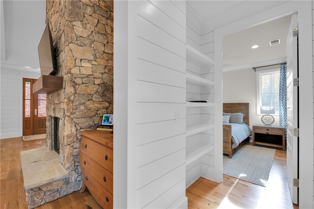 243 Quay Court Sunset, SC 29685 - Photo 19 of 46 This interior offers a stone fireplace and built-in shelving next to a welcoming bedroom entry.