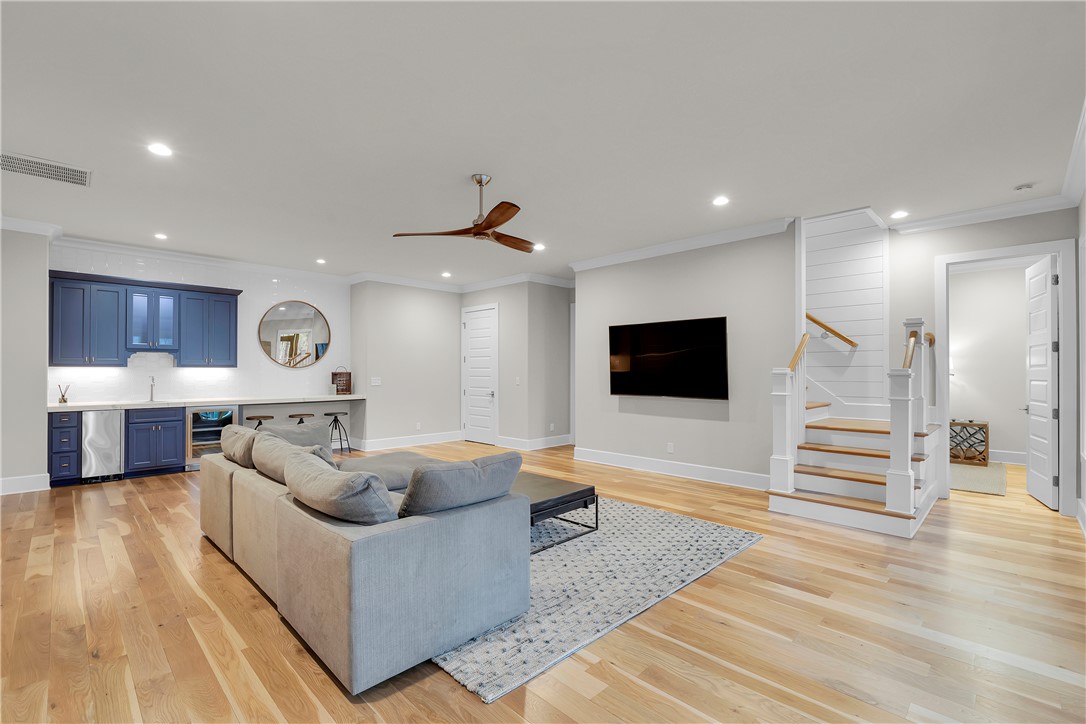 243 Quay Court Sunset, SC 29685 - Photo 23 of 46 This living area features a wet bar, hardwood floors, and a staircase leading to additional levels.