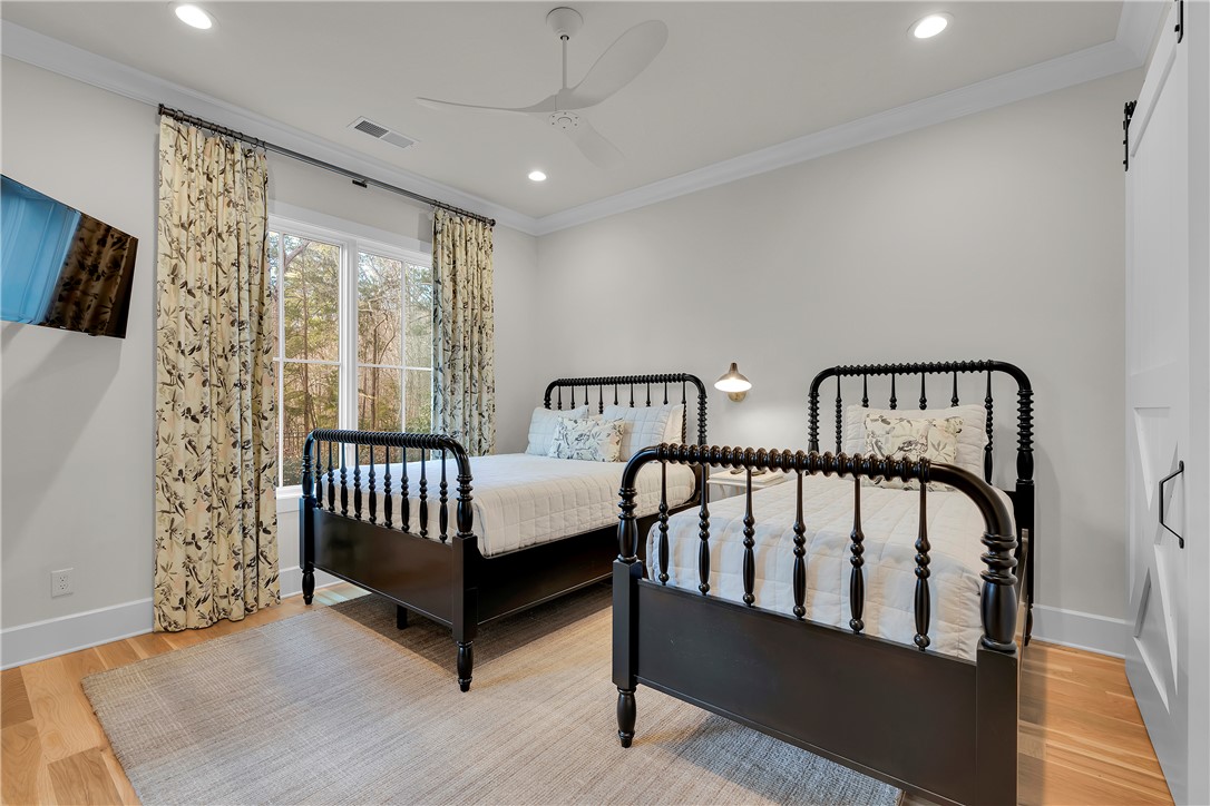 243 Quay Court Sunset, SC 29685 - Photo 26 of 46 This bright and inviting bedroom features hardwood floors and a sliding barn door, perfect for modern living.