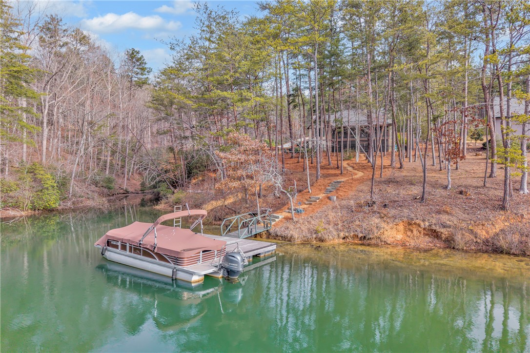 243 Quay Court Sunset, SC 29685 - Photo 41 of 46 This serene lakeside property boasts a private dock and direct water access, enveloped by mature trees.