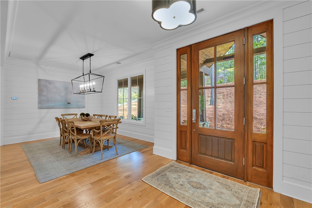 243 Quay Court Sunset, SC 29685 - Photo 6 of 46 This inviting dining area features warm hardwood floors and a striking modern chandelier, perfect for memorable gatherings.