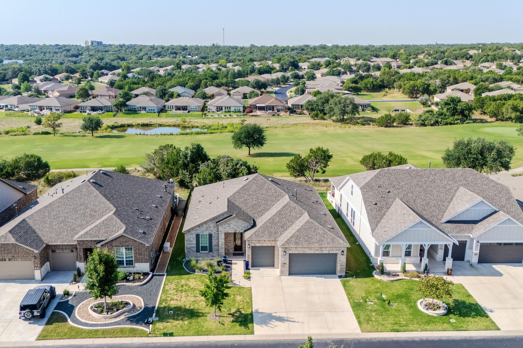 Aerial perspective of suburban area featuring a large body of water and a golf club