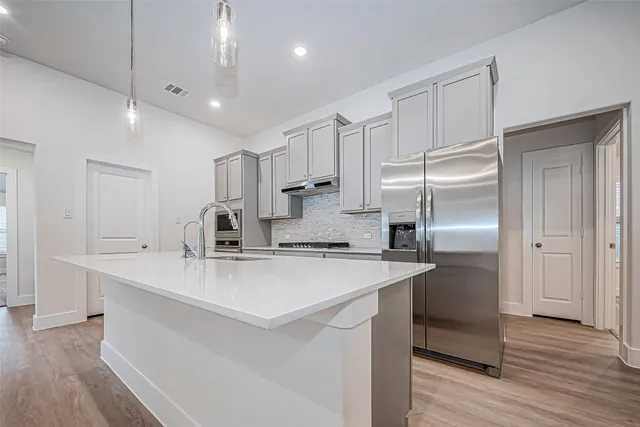 a kitchen with kitchen island a sink stainless steel appliances and cabinets