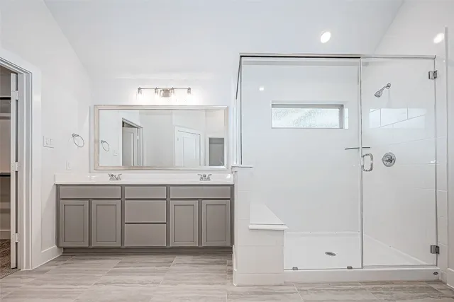 a spacious bathroom with a shower sink and mirror