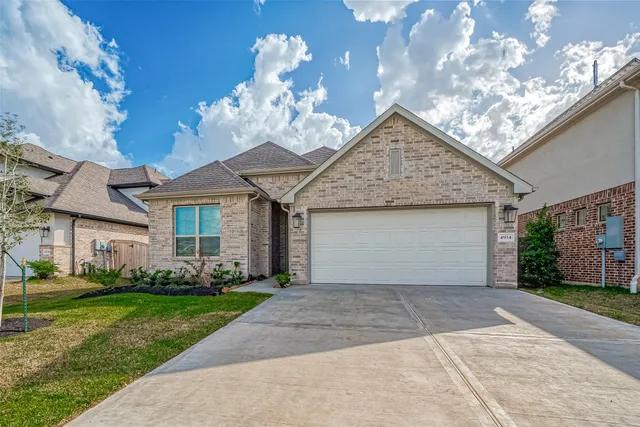 a front view of a house with a garden and plants