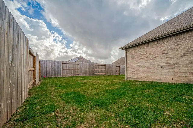 a view of a backyard with wooden fence