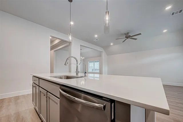 a kitchen with a sink a counter space and cabinets