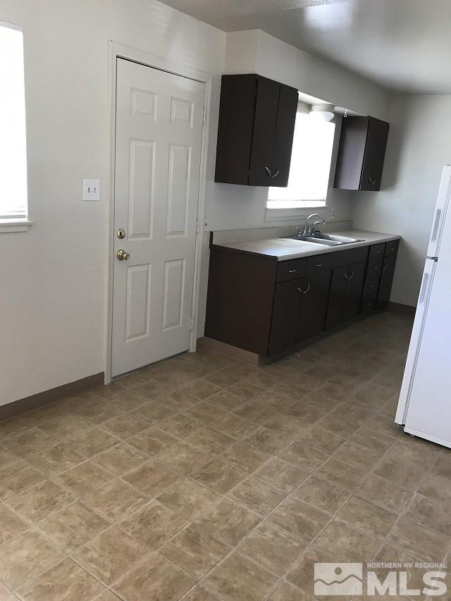 1175 Goldfield Street Reno, NV 89512 - Photo 4 of 7 a kitchen with granite countertop a sink and a stove