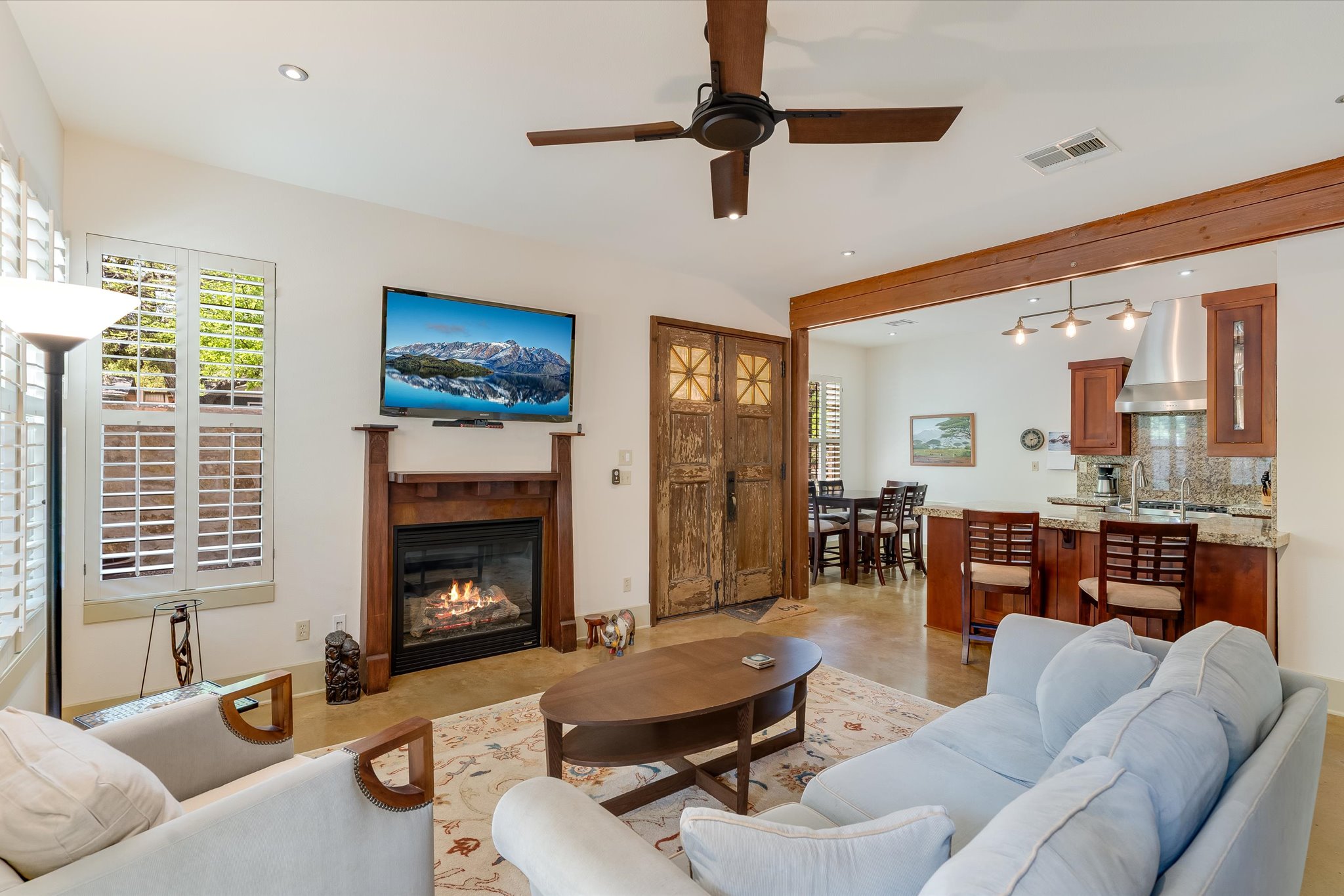 2405 Kinney Road, Unit 2405 Austin, TX 78704 - Photo 2 of 15 Living area featuring a gas fireplace, ceiling fan and doors leading to the private courtyard