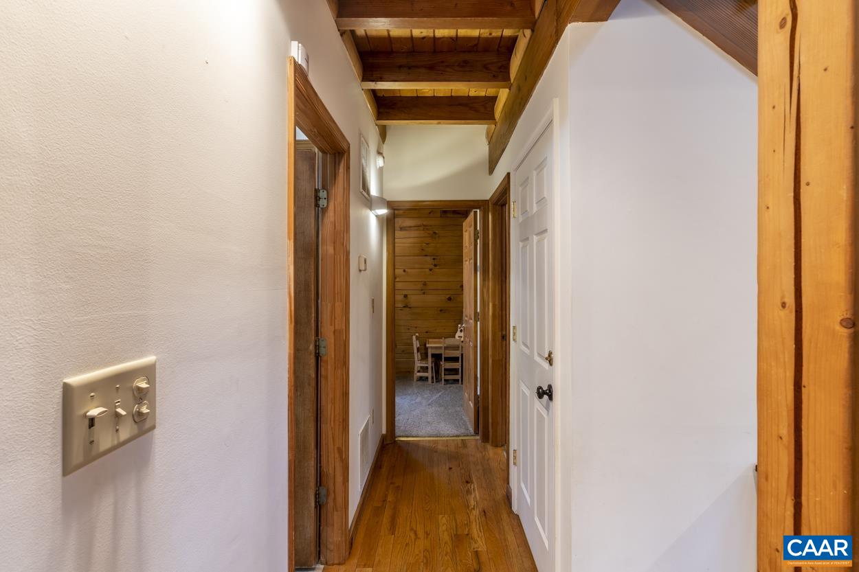 136 Buffalo Run Road Stanardsville, VA 22973 - Photo 17 of 64 a view of a hallway with wooden floor and a bathroom