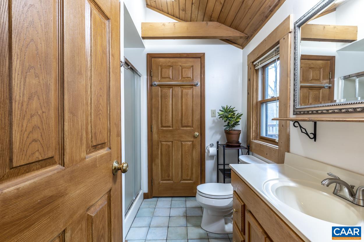 136 Buffalo Run Road Stanardsville, VA 22973 - Photo 28 of 64 a bathroom with a sink a toilet and shower curtain
