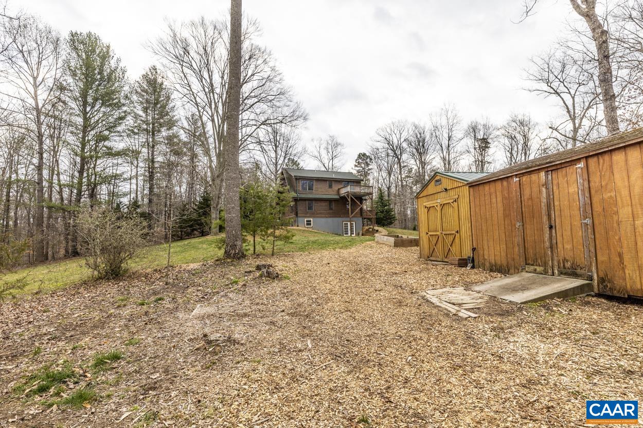 136 Buffalo Run Road Stanardsville, VA 22973 - Photo 50 of 64 a backyard of a house with large trees and covered by side of it