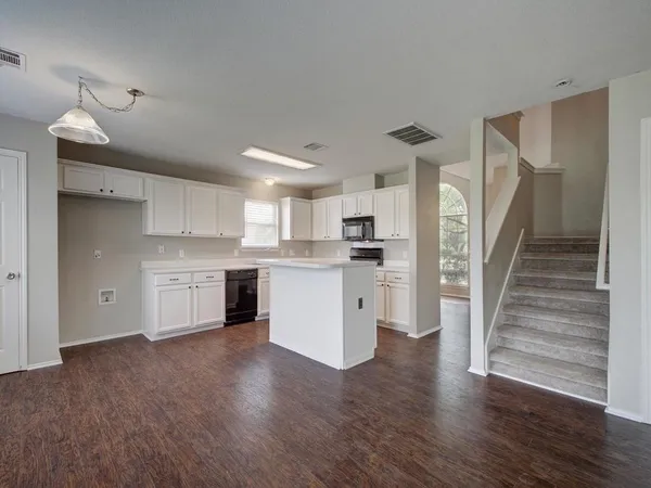 a view of kitchen with wooden floor and electronic appliances