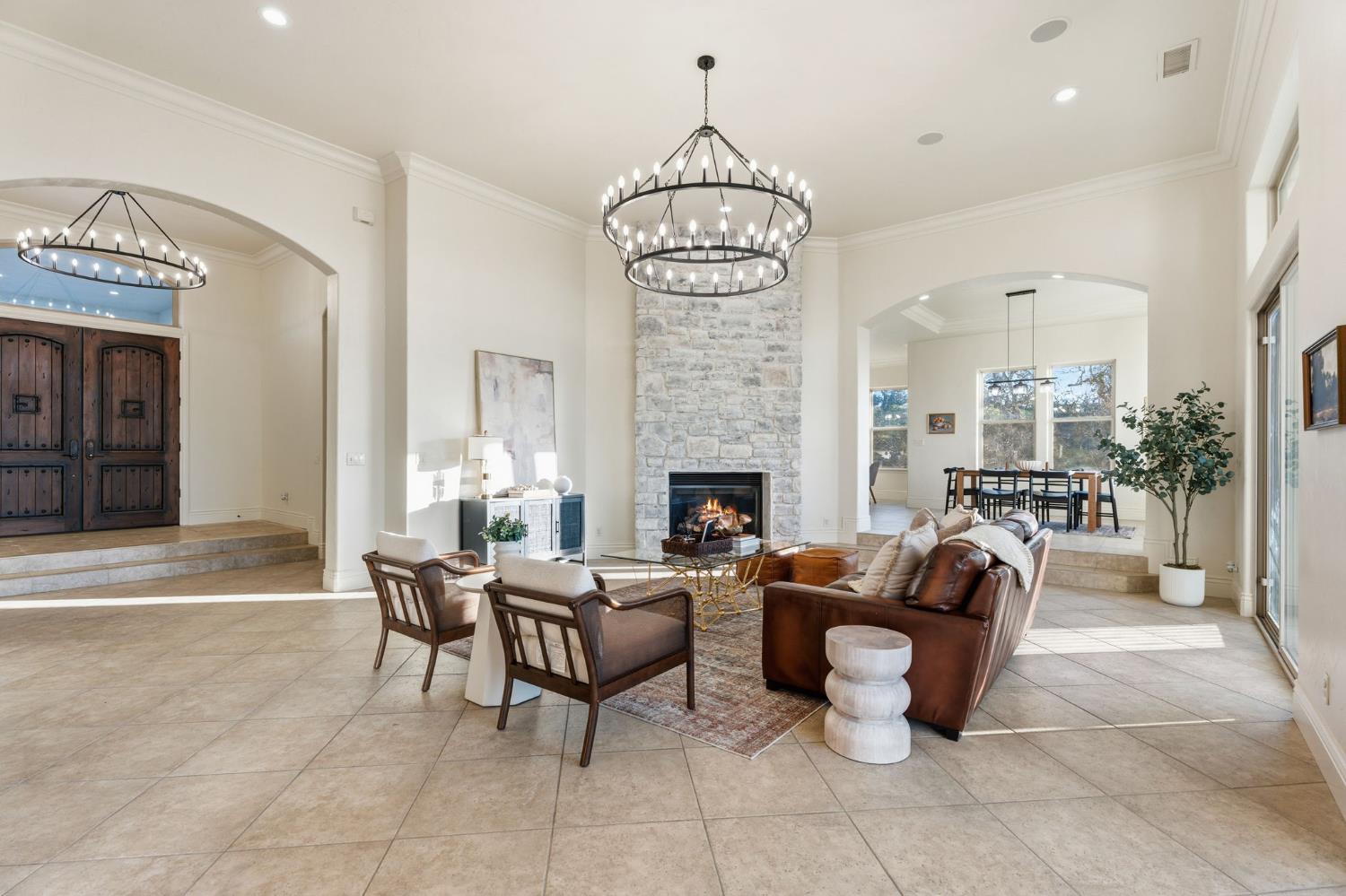 22221 Masters Drive Friant, CA 93626 - Photo 59 of 87 a living room with furniture a fireplace and a chandelier