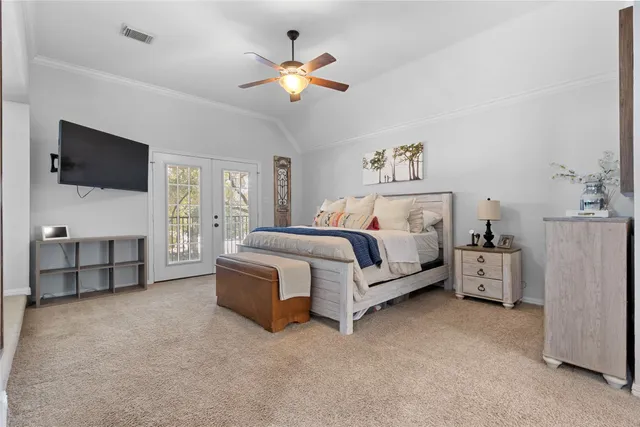 a spacious bedroom with a bed and a flat screen tv