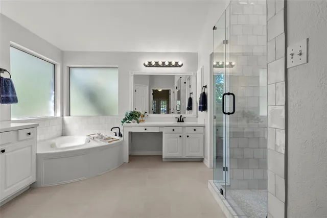 a bathroom with a double vanity sink mirror and bathtub