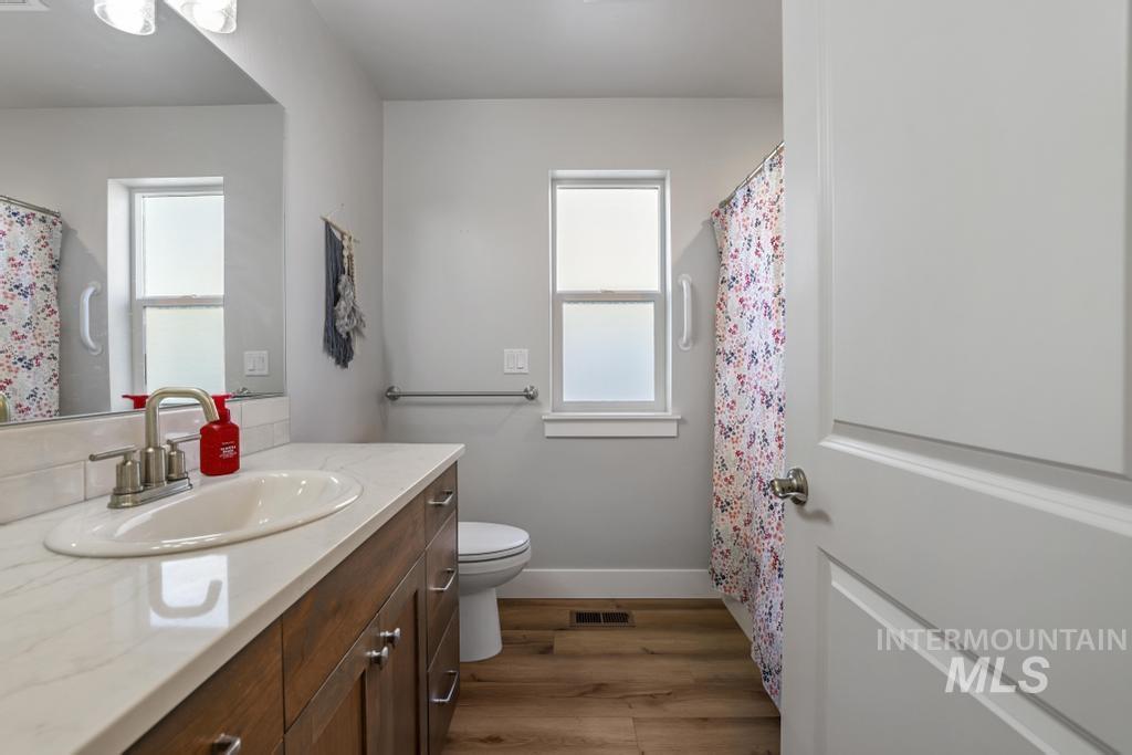 4073 Williams Street Buhl, ID 83316 - Photo 23 of 31 Bathroom featuring vanity, curtained shower, dark wood-type flooring, and healthy amount of natural light