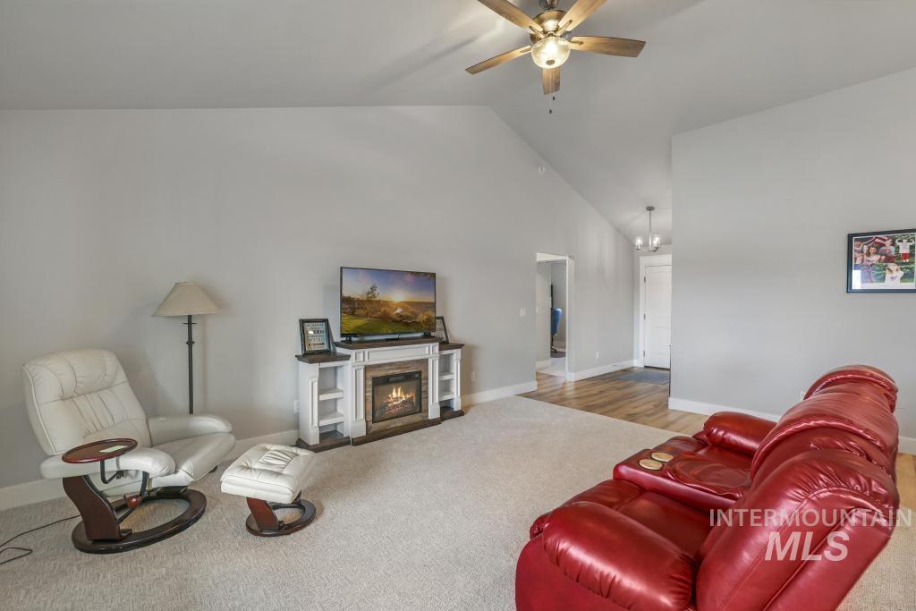 4073 Williams Street Buhl, ID 83316 - Photo 8 of 31 Carpeted living room with vaulted ceiling, a glass covered fireplace, and ceiling fan