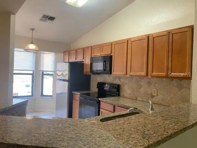 a kitchen with stainless steel appliances granite countertop a refrigerator sink and cabinets