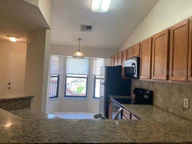 a kitchen with stainless steel appliances granite countertop a refrigerator and a sink