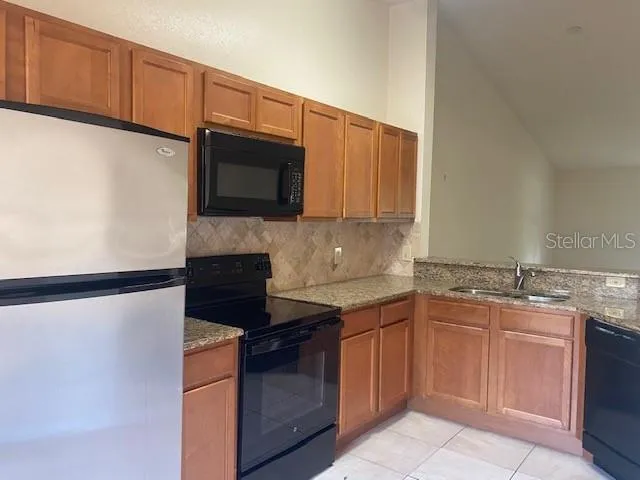 a kitchen with granite countertop cabinets stainless steel appliances and a sink
