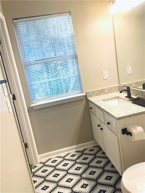 357 Waits Drive Southwest, Unit 1 Atlanta, GA 30331 - Photo 5 of 8 a bathroom with a sink a toilet a mirror and a window