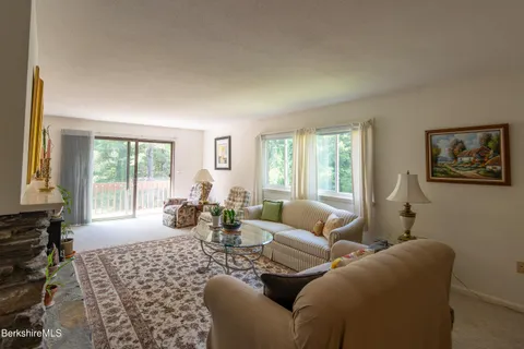 a living room with furniture large window and lamp