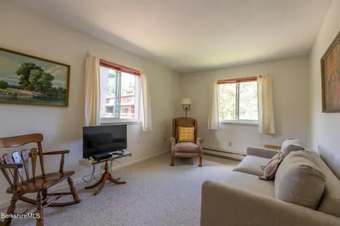 a living room with furniture a flat screen tv and a window