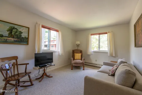 a living room with furniture a flat screen tv and a window