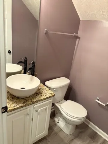 a white toilet sitting next to a bathroom sink and a mirror