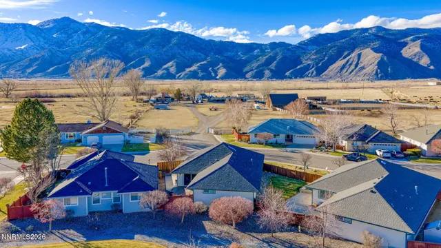 a view of a patio with couches table and chairs under an umbrella with a fire pit