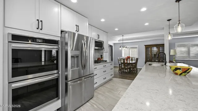 a kitchen with stainless steel appliances a stove a refrigerator and a fireplace