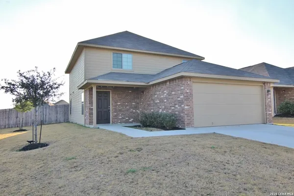 a front view of a house with yard and garage