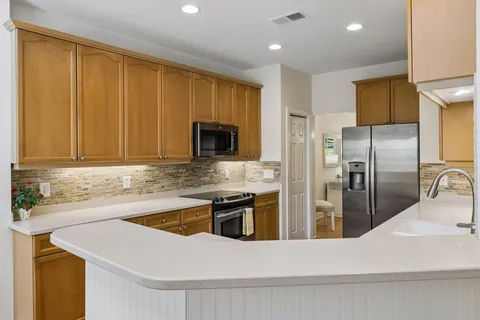 a kitchen with a sink a microwave and cabinets