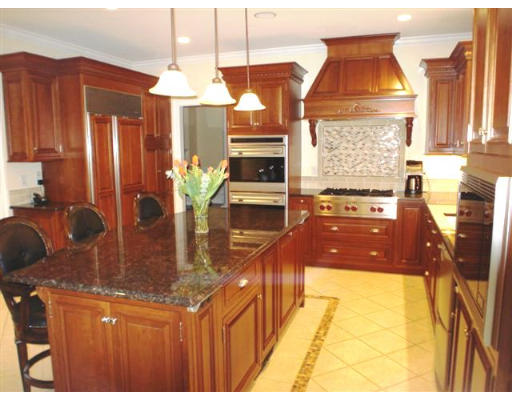 125 Conant Road Weston, MA 02493 - Photo 4 of 16 a kitchen with stainless steel appliances kitchen island granite countertop a stove a sink and a microwave